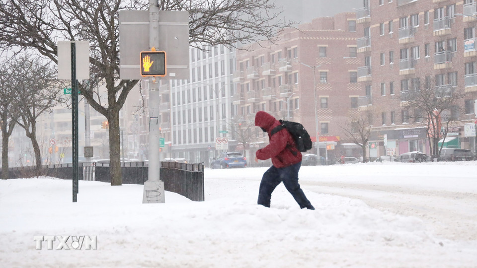 Người dân băng qua đường trong "biển tuyết." (Ảnh: Thanh Tuấn/TTXVN)