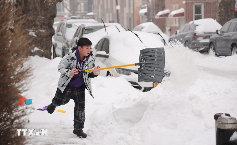 Người dân dọn tuyết trước cả nhà. (Ảnh: Thanh Tuấn/TTXVN)