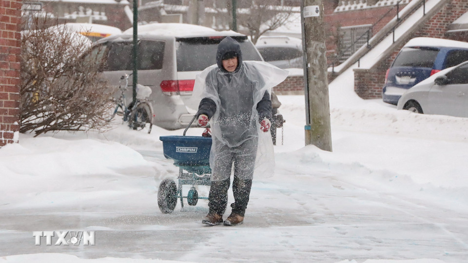 Người dân rải muối để chống trơn trượt. (Ảnh: Thanh Tuấn/TTXVN)