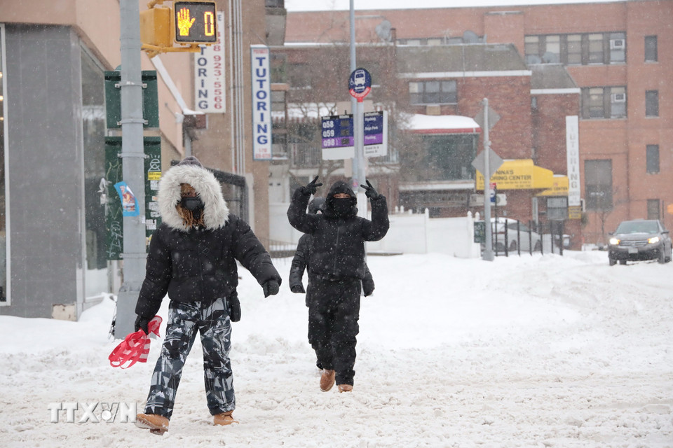 Người dân băng qua đường trong "biển tuyết." (Ảnh: Thanh Tuấn/TTXVN)