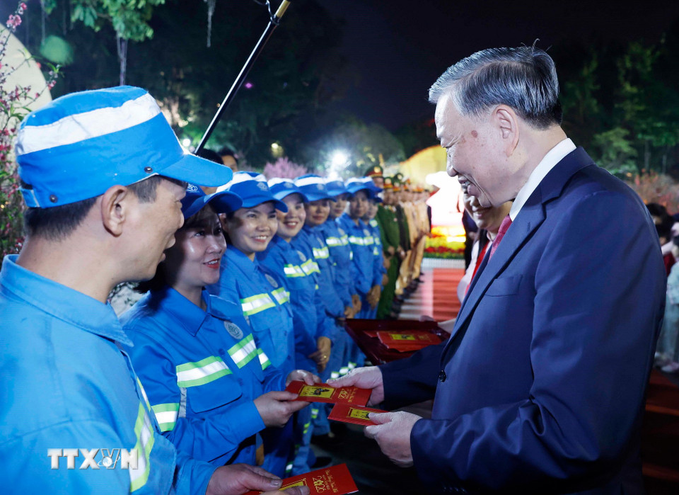 Tổng Bí thư Tô Lâm mừng tuổi cho công nhân môi trường đô thị tại khu vực vườn hoa Lý Thái Tổ. (Ảnh: Thống Nhất/TTXVN)