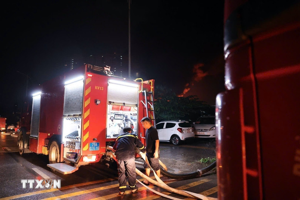 Công an thành phố Hà Nội điều động nhiều xe chữa cháy cùng cán bộ, chiến sỹ đến hiện trường đám cháy. (Ảnh: Phạm Kiên/TTXVN)
