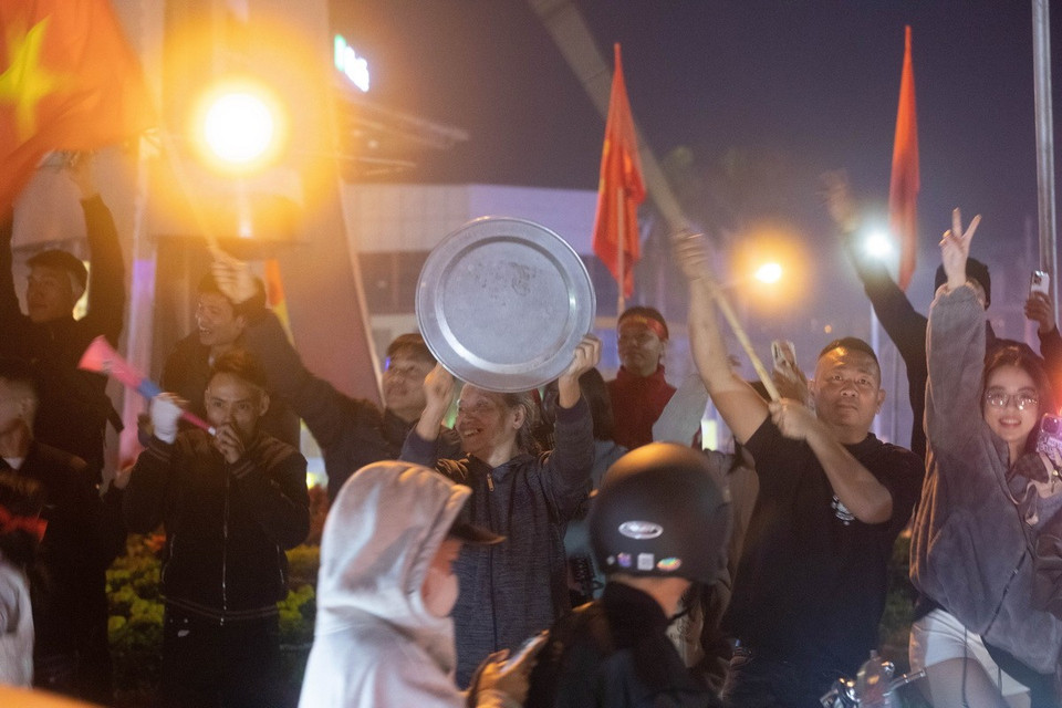 Người hâm mộ cầm cờ, kèn…đổ ra đường sau khi xem trận chung kết lượt về. (Ảnh: Vũ Quang/TTXVN)