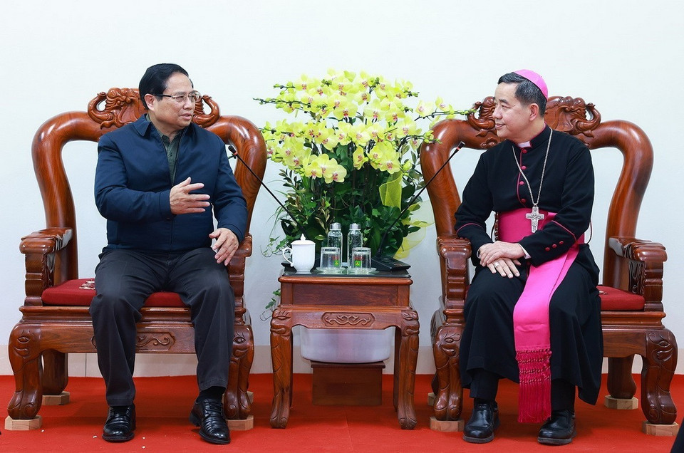 Thủ tướng Phạm Minh Chính chúc mừng Giám mục Giáo phận Hưng Hóa Hoàng Minh Tiến và các chức sắc, chức việc Giáo xứ Lào Cai. (Ảnh: Dương Giang/TTXVN)