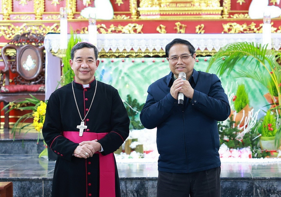 Thủ tướng Phạm Minh Chính chúc mừng Giám mục Giáo phận Hưng Hóa Hoàng Minh Tiến và các chức sắc, chức việc Giáo xứ Lào Cai. (Ảnh: Dương Giang/TTXVN)