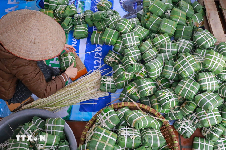 Đôi tay người thợ thoăn thoắt gói bánh, từng nếp gấp vuông vắn cho thấy sự thuần thục được tích lũy qua nhiều năm gắn bó với nghề. (Ảnh: Khánh Hòa/TTXVN)