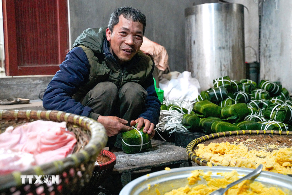 Đôi tay người thợ thoăn thoắt gói bánh, từng nếp gấp vuông vắn cho thấy sự thuần thục được tích lũy qua nhiều năm gắn bó với nghề. (Ảnh: Khánh Hòa/TTXVN)