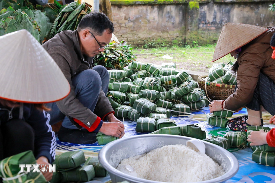 Cả gia đình cùng gói bánh, tạo nên không khí lao động đầm ấm, gắn kết trong mùa Tết. (Ảnh: Khánh Hòa/TTXVN)