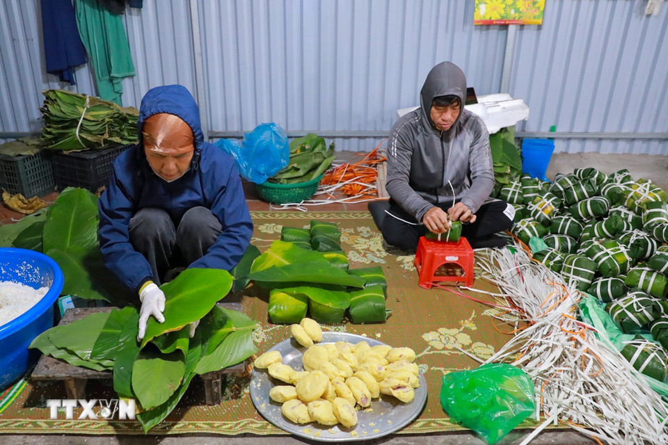Đôi tay người thợ thoăn thoắt gói bánh, từng nếp gấp vuông vắn cho thấy sự thuần thục được tích lũy qua nhiều năm gắn bó với nghề. (Ảnh: Khánh Hòa/TTXVN)