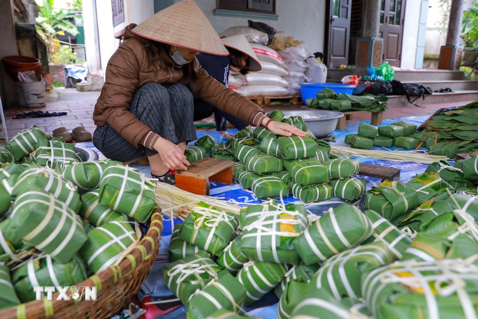 Đôi tay người thợ thoăn thoắt gói bánh, từng nếp gấp vuông vắn cho thấy sự thuần thục được tích lũy qua nhiều năm gắn bó với nghề. (Ảnh: Khánh Hòa/TTXVN)
