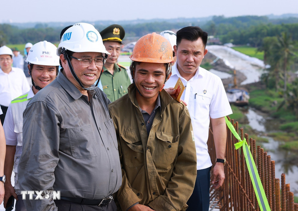 Thủ tướng Phạm Minh Chính thăm hỏi, chúc Tết công nhân thi công dự án đường Vành đai 3 Thành phố Hồ Chí Minh đoạn Tân Vạn-Nhơn Trạch. (Ảnh: Dương Giang/TTXVN)