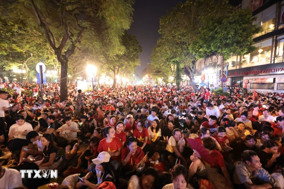 Khu vực Quảng trường cách mạng tháng Tám, người dân hòa trong sắc cờ đỏ, sao vàng cùng nhau chờ thời khắc Lễ diễu binh, diễu hành kỷ niệm 80 năm Quốc khánh. (Ảnh: Trần Việt/TTXVN)