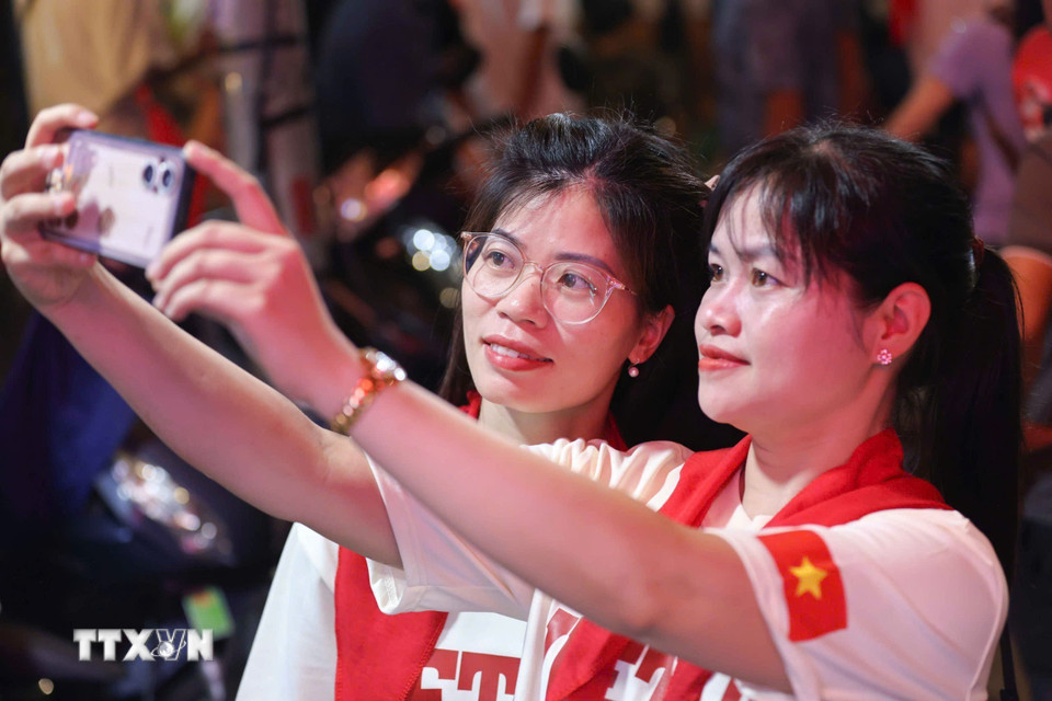 Người dân hòa trong sắc cờ đỏ, sao vàng cùng nhau chờ thời khắc Lễ diễu binh, diễu hành kỷ niệm 80 năm Quốc khánh. (Ảnh: Thanh Tùng/TTXVN)