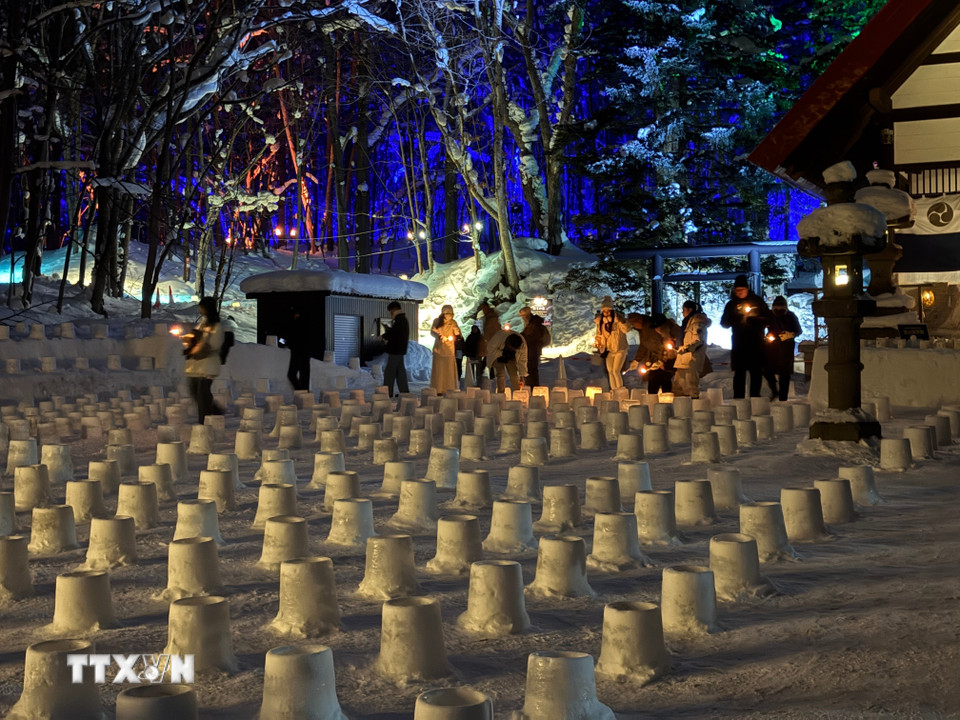 Du khách thắp những ngọn đèn làm từ tuyết và nến. (Ảnh: Xuân Giao/TTXVN)