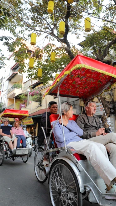 Du khách nước ngoài sử dụng xíchlô thưởng ngoạn nét đẹp cổ kính của Phố cổ Hà Nội. (Ảnh: Thanh Tùng/TTXVN)