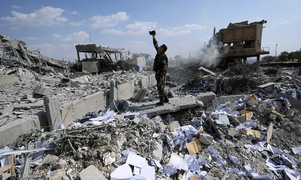 Một người lính Syria chụp ảnh tại đống đổ nát ở Trung tâm nghiên cứu khoa học gần Damascus (Nguồn: AP) Syria: Hình ảnh đổ nát tại trung tâm nghiên cứu khoa học bị không kích ảnh 1