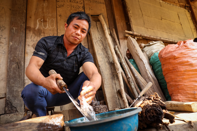 Anh Cứ A Dụ dùng đá suối và nước để mài dao cho sắc. (Ảnh: Hoài Nam/Vietnam+) vnp_ rendao 10.jpg