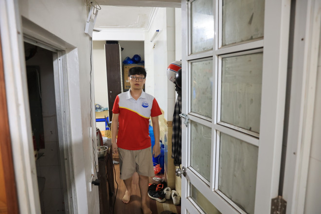 Phước ở căn phòng trọ chật hẹp tại tầng 1 trong tòa nhà, có lối thoát nạn duy nhất là cửa ra vào, nơi để hàng chục chiếc xe máy của toàn bộ người thuê trọ. (Ảnh: Hoài Nam/Vietnam+) vnp_2.JPG