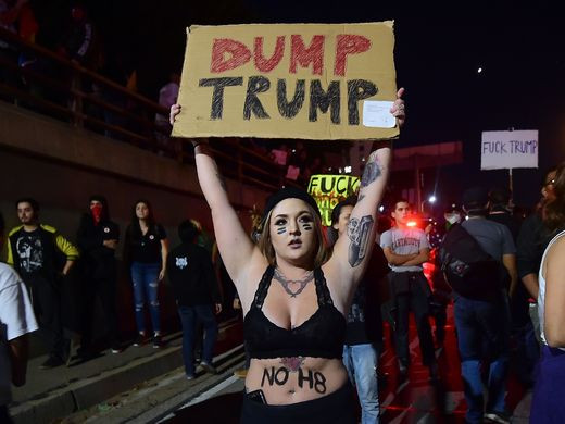 Người biểu tình phản đối ông Donald Trump đập phá ôtô ngoài phố ảnh 1