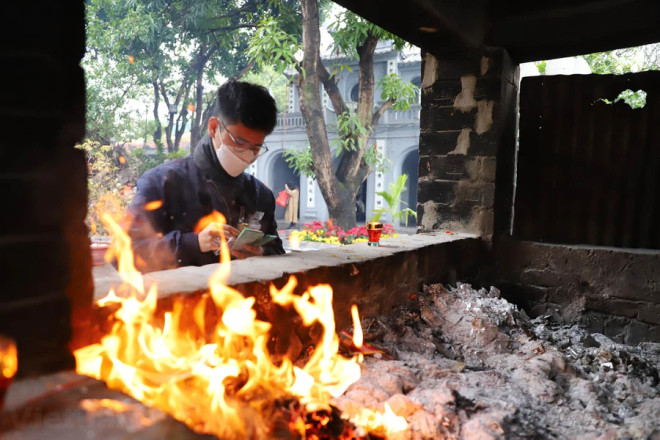 Người dân cần đốt vàng mã đúng nơi quy định tại đền, chùa. (Ảnh: Hoài Nam/Vietnam+) vnp__gioi_tre_cau_duyen_11.JPG