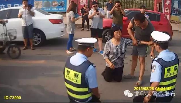 Cảnh sát giao thông Trung Quốc quỳ xuống đất để giải thích cho dân ảnh 2