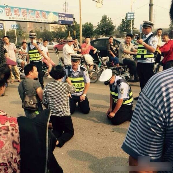 Cảnh sát giao thông Trung Quốc quỳ xuống đất để giải thích cho dân ảnh 1