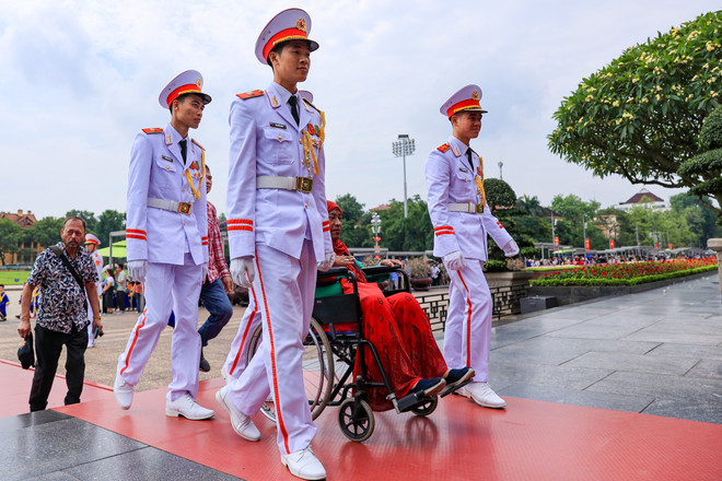 Các chiến sĩ thuộc Bộ Tư lệnh Bảo vệ Lăng đưa một du khách nước ngoài ngồi xe lăn vào viếng Lăng Bác. (Ảnh: Hoài Nam/Vietnam+) vnp_ vieng lang Bac 10.jpg