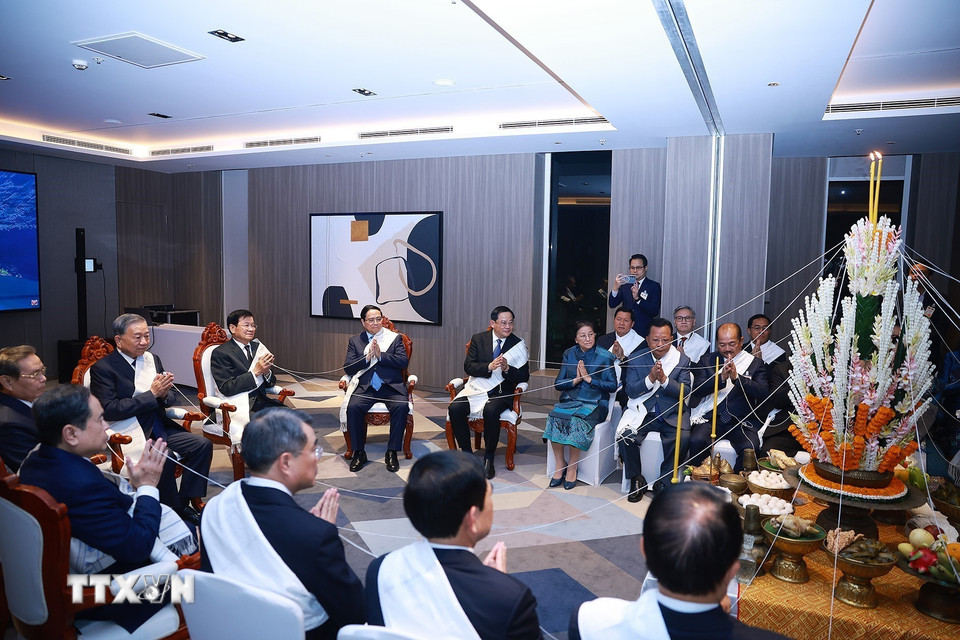 Nghi lễ buộc chỉ cổ tay truyền thống của Lào. (Ảnh: Dương Giang/TTXVN)