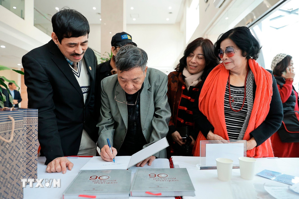 Tác giả Ngô Minh Đạo ký tặng sách cho đại biểu. (Ảnh: Minh Quyết/TTXVN)