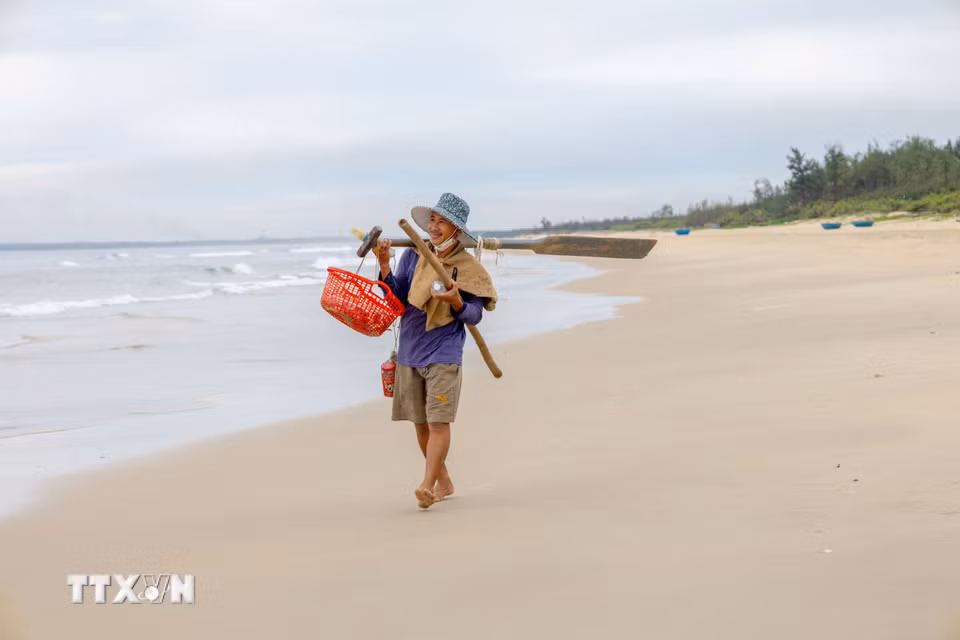 Sau chuyến biển xuyên đêm, người đàn ông vui vẻ thu dọn ngư cụ, chuẩn bị trở về nhà sau một đêm lao động trên biển. (Ảnh: Xuân Quý/TTXVN)
