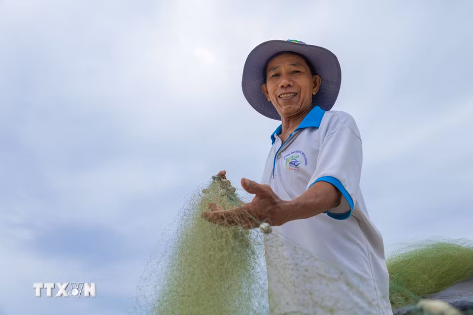 Những tấm lưới được kéo lên bờ, phơi trên bãi cát sau chuyến đi biển đêm của ngư dân Tam Tiến. (Ảnh: Xuân Quý/TTXVN)