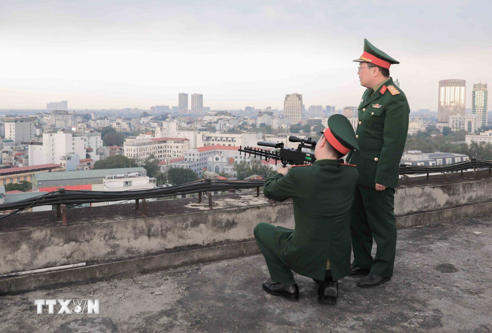 Tại các vị trí cao như nóc nhà, thuận lợi cho quan sát, các chiến sĩ thực hành sử dụng súng CAV-14 chế áp phương tiện bay không người lái, kịp thời phát hiện mục tiêu, bảo đảm an toàn tuyệt đối khu vực bầu cử. (Ảnh: Phan Phương/TTXVN)