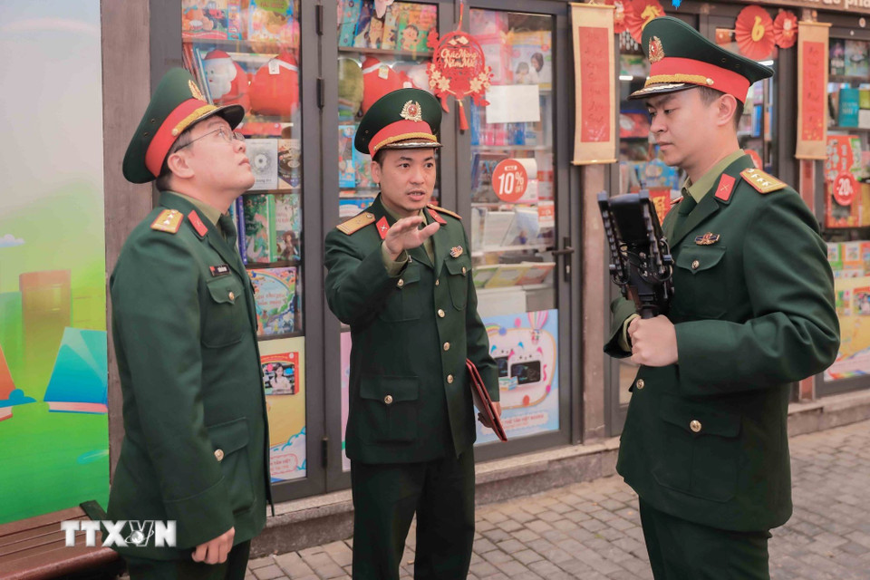 Thiếu tá Trần Quang Trung, Phó Chỉ huy trưởng Ban Chỉ huy Quân sự phường Cửa Nam trực tiếp chỉ đạo lực lượng an ninh sử dụng súng CAV-14, chế áp phương tiện bay không người lái, bảo đảm an toàn tuyệt đối khu vực bầu cử. (Ảnh: Phan Phương/TTXVN)