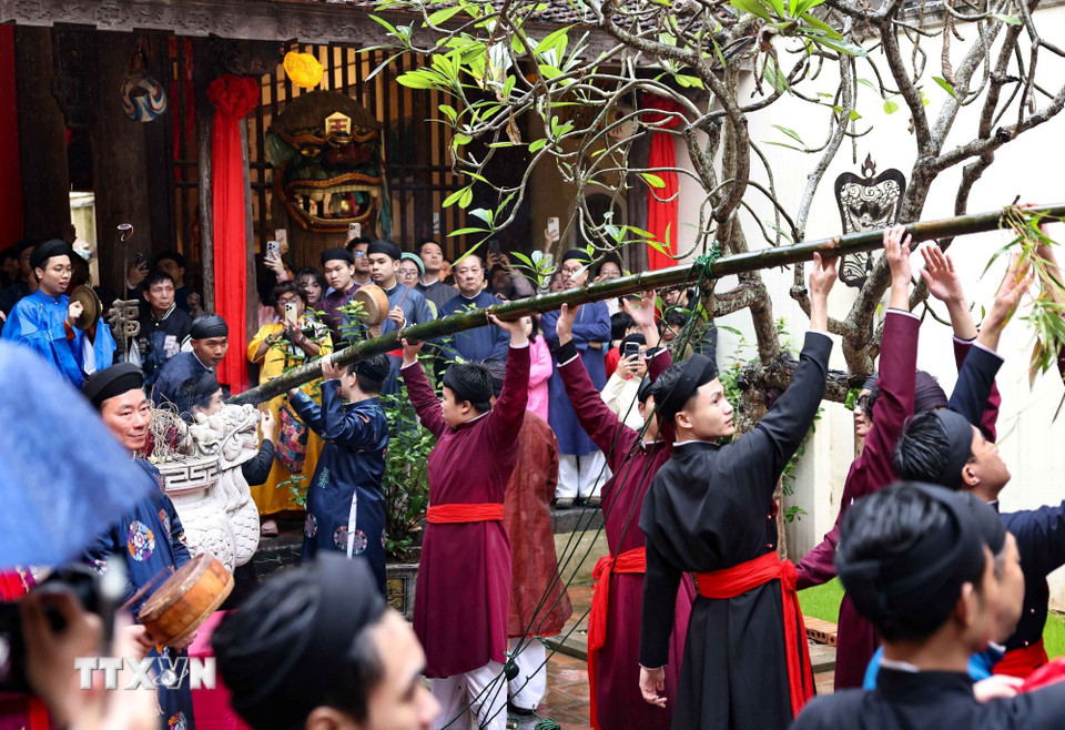 Cùng chung tay dựng cây nêu ngày Tết tại đình Kim Ngân. (Ảnh: Thanh Tùng/TTXVN)