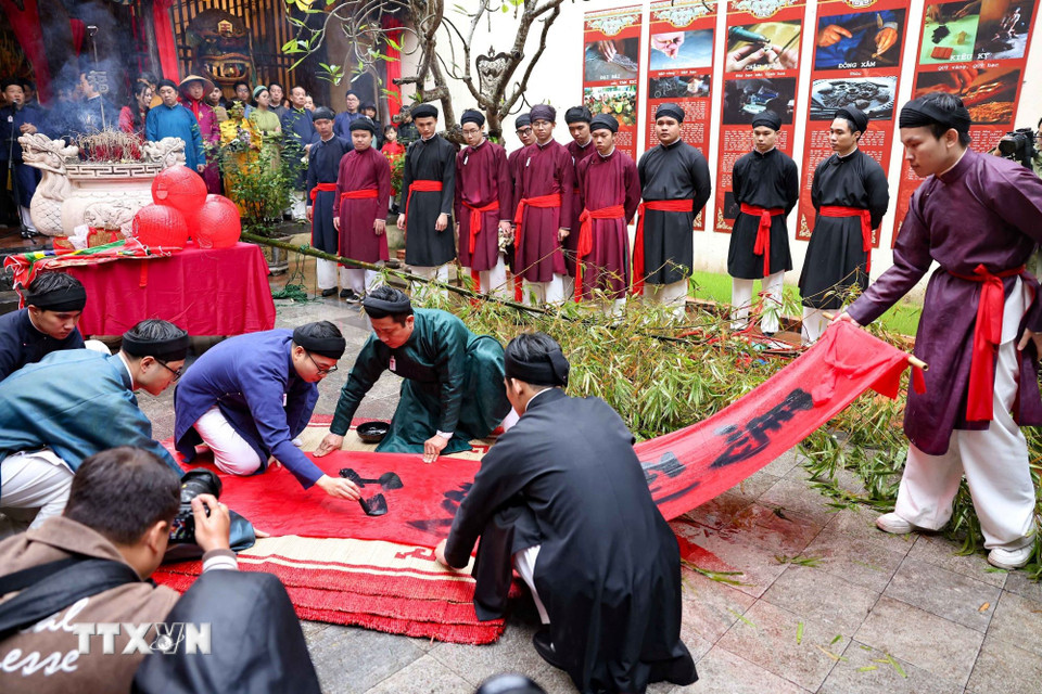 Bốn chữ “Mã đáo thành công” được viết vào dải lụa đỏ để treo trên ngọn cây nêu. (Ảnh: Thanh Tùng/TTXVN)