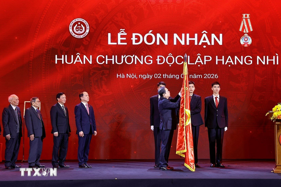 Chủ tịch Quốc hội Trần Thanh Mẫn gắn Huân chương Độc lập hạng Nhì lên lá cờ truyền thống của Ủy ban Pháp luật và Tư pháp của Quốc hội. (Ảnh: Doãn Tấn/TTXVN)