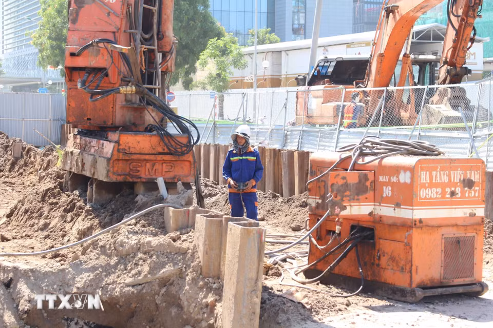Công nhân nỗ lực làm việc trong điều kiện thời tiết nắng nóng, để kịp tiến độ dự án. (Ảnh: Nguyễn Thắng/TTXVN)