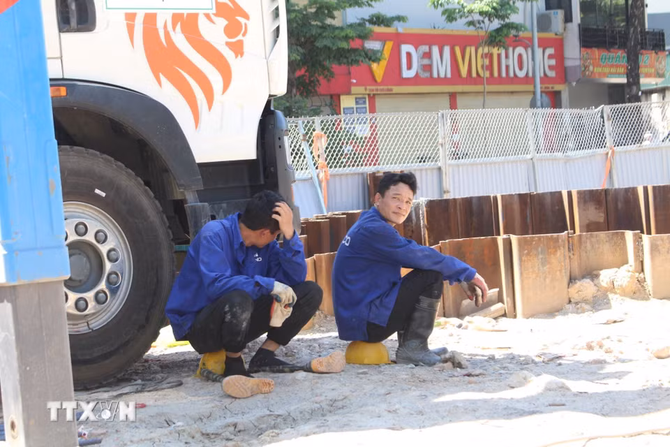 Công nhân tranh thủ nghỉ ngơi trong điều kiện thi công nắng nóng gay gắt trên đường Võ Chí Công. (Ảnh: Nguyễn Thắng/TTXVN)