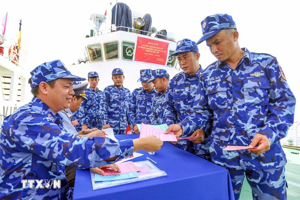 Cử tri trên tàu trực nhận phiếu bầu. (Ảnh: TTXVN phát)