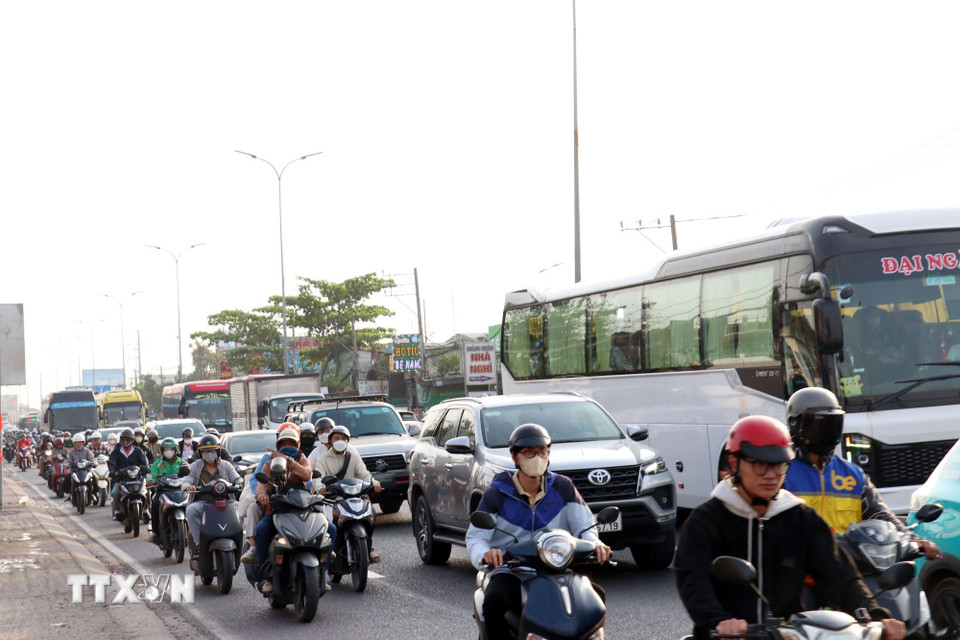 Phương tiện xếp hàng dài, di chuyển chậm qua các nút giao trên Quốc lộ 1, đoạn từ nút giao với đường Nguyễn Văn Linh đến đường Nguyễn Hữu Trí. (Ảnh: Tiến Lực/TTXVN)