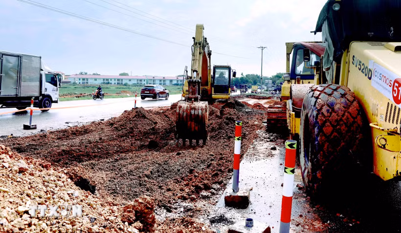 Máy xúc đang tiến hành đào hạ nền đường để mở rộng tuyến, Quốc lộ 2 đoạn qua xã Vinh Hưng. (Ảnh: Hoàng Hùng/TTXVN)