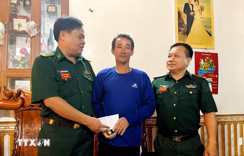 Chỉ huy Đồn Biên phòng Cửa khẩu Cảng Gianh (Bộ đội Biên phòng tỉnh Quảng Trị) thăm hỏi ngư dân Nguyễn Mạnh Cường, động viên gia đình sớm ổn định cuộc sống. (Ảnh: TTXVN phát)