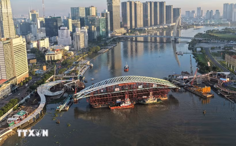 Toàn cảnh sà lan chở nhịp chính được đưa vào vị trí hợp long dự án cầu đi bộ qua sông Sài Gòn. (Ảnh: Minh Linh/TTXVN)