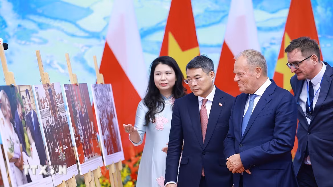 Thủ tướng Lê Minh Hưng và Thủ tướng Cộng hòa Ba Lan Donald Tusk tham quan trưng bày ảnh về quan hệ hợp tác giữa hai nước do Thông tấn xã Việt Nam thực hiện. (Ảnh: Dương Giang/TTXVN)