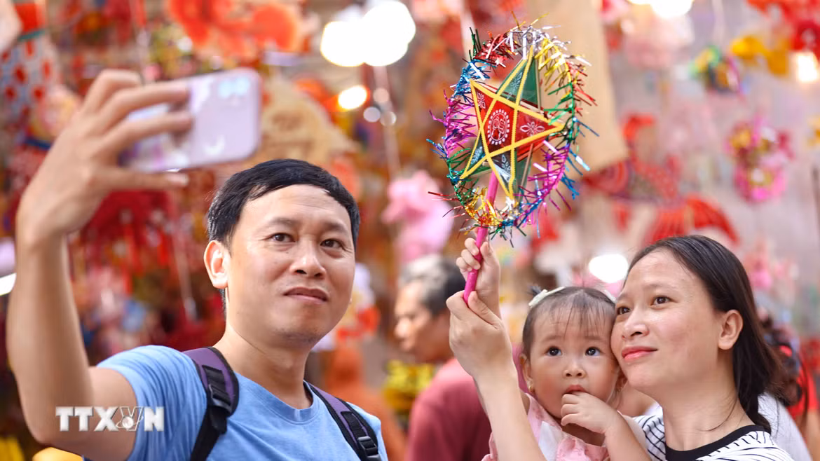 Lưu lại khoảnh khắc đẹp trong không khí rực rỡ sắc màu của chợ Trung Thu truyền thống. (Ảnh: Thanh Tùng/TTXVN)