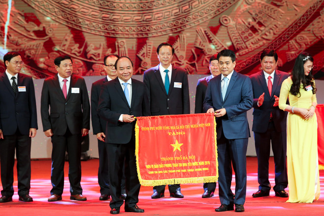 Ông Nguyễn Đức Chung, Chủ tịch Ủy ban Nhân dân Thành phố Hà Nội vinh dự nhận cờ thi đua dành cho các tỉnh thành phố có phong trào thi đua xuất sắc trong năm 2017. (Ảnh: Minh Sơn/Vietnam+) Tuyên dương 377 điển hình tiên tiến toàn quốc năm 2017 ảnh 9