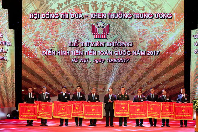 Thủ tướng Nguyễn Xuân Phúc trao cờ thi đua cho các bộ, ngành có thành tích xuất sắc trong năm 2017. (Ảnh: Minh Sơn/Vietnam+) Tuyên dương 377 điển hình tiên tiến toàn quốc năm 2017 ảnh 11