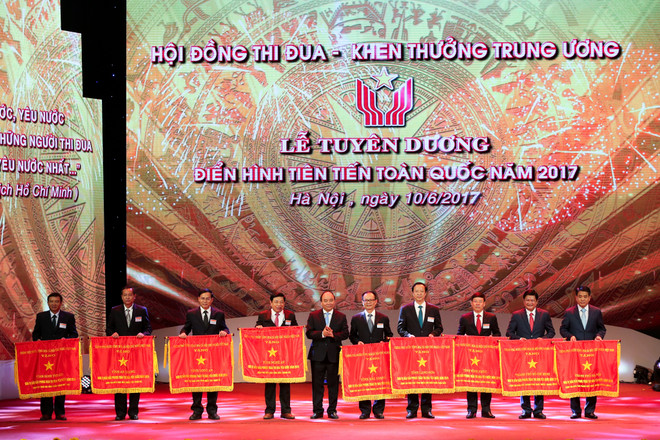 Thủ tướng Nguyễn Xuân Phúc trao cờ thi đua cho các tỉnh, thành phố có phong trào thi đua xuất sắc trong năm 2017. (Ảnh: Minh Sơn/Vietnam+) Tuyên dương 377 điển hình tiên tiến toàn quốc năm 2017 ảnh 10