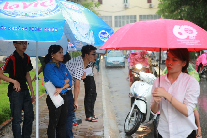 Sinh viên tình nguyện dùng ô to đưa sĩ tử thoát cơn mưa rào ảnh 9