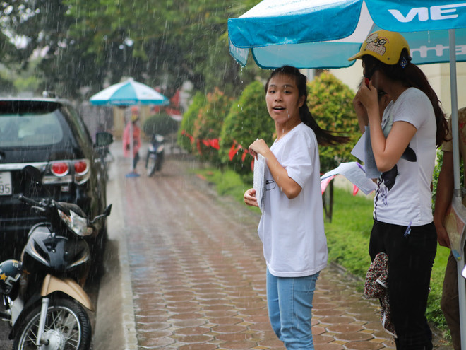 Sinh viên tình nguyện dùng ô to đưa sĩ tử thoát cơn mưa rào ảnh 11